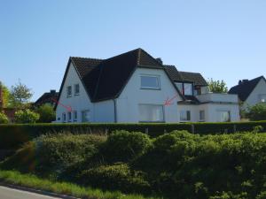 una gran casa blanca con techo negro en Ferienwohnung Haffblick, en Westerholz