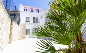 una palmera frente a un edificio blanco en Apartamentos Castelo, en Póvoa de Varzim