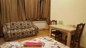 sala de estar con mesa, silla y sofá en "Green way" Guest house, en Tiflis