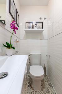 a white bathroom with a toilet and a sink at Apartamento Gran Via Center in Granada