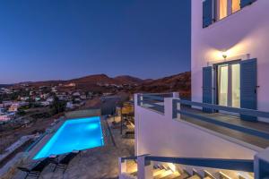 a villa with a swimming pool at night at Oceania House with sea view in Ano Syros