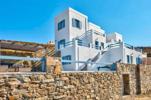 a large white building on top of a stone wall at Oceania House with sea view in Ano Syros