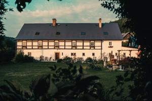 a large white house with a black roof at Pension Rokytka in Kryštofovo Údolí