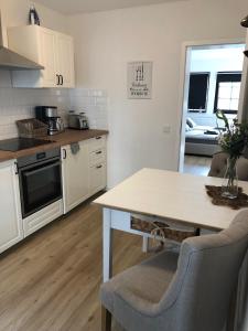 a kitchen with white cabinets and a table with chairs at Altstadt Quartier Hameln in Hameln