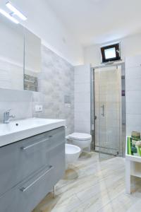 a white bathroom with a sink and a toilet at Il Profumo di Capri in Massa Lubrense