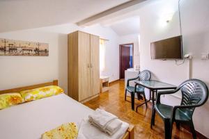 Guest House Lotos في بيشيشي: غرفة نوم بها سرير وطاولة وكراسي