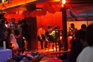una multitud de personas sentadas en una habitación con luces rojas en Tri-Shawa Resort, en Klong Wan