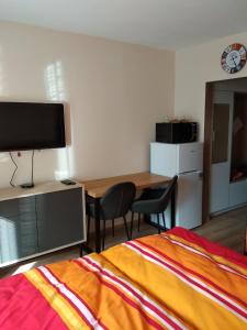 a bedroom with a bed and a desk and a table with chairs at Apartmán ALEX in Poprad