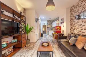 ein Wohnzimmer mit einem Sofa und einem Tisch in der Unterkunft Apartamento Gran Via Center in Granada