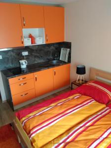 sypialnia z pomarańczowymi szafkami i łóżkiem w obiekcie Apartmán ALEX w Popradzie