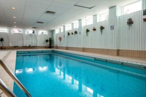 a large swimming pool with blue water in a building at Ramundbergets Fjällgård in Ramundberget