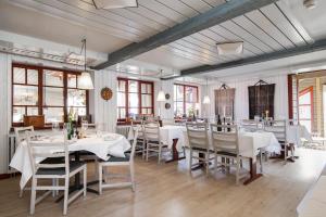 a dining room with white tables and chairs at Ramundbergets Fjällgård in Ramundberget