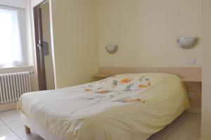 ジェラールメにあるHotel Gai Relaisの白いベッド(花付)が備わるベッドルームです。