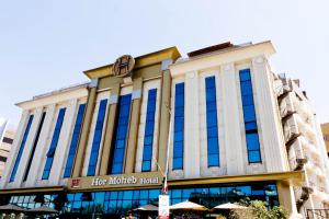 a large building with blue windows on a street at Hor Moheb Hotel in Cairo