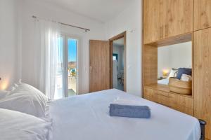 - une chambre avec un grand lit blanc et un miroir dans l'établissement Oceania House with sea view, à Áno Sýros