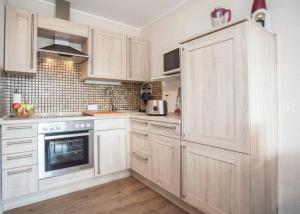 a kitchen with white cabinets and a stove top oven at Ferienwohnung Hilleseeblick in Winterberg +20 photos