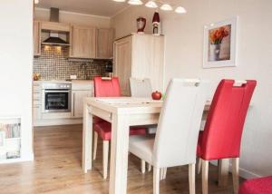 a kitchen with a wooden table and red chairs at Ferienwohnung Hilleseeblick in Winterberg