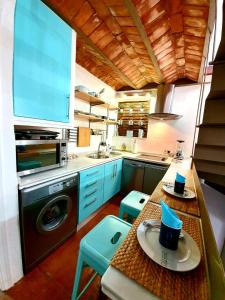 cocina con fregadero y mesa con taburetes azules en Almocabar Luxury Apartment, en Ronda