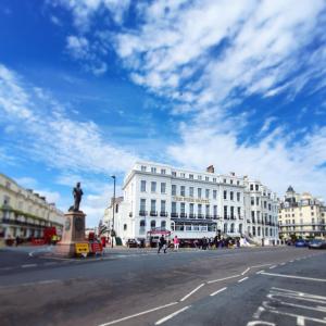 a large white building with a statue in the middle of a street at The Pier Hotel in Eastbourne