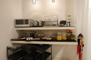 a kitchen with a microwave and a table with food at Mecla Suites in Naples