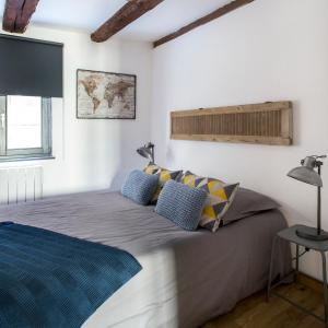 a bedroom with a large bed with blue pillows at La Maison du Batelier in Colmar