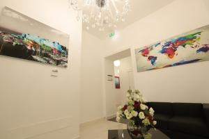 sala de estar con sofá y pinturas en la pared en Mecla Suites, en Nápoles