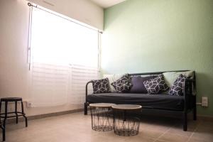 Una sala de estar con un sofá y dos mesas. en le studio du Grazel, en Gruissan