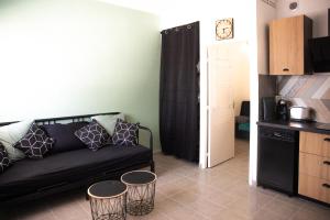 sala de estar con sofá negro y 2 taburetes en le studio du Grazel, en Gruissan 10 fotos más