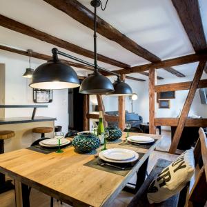 une salle à manger avec une table en bois et des lumières noires dans l'établissement La Maison du Batelier, à Colmar