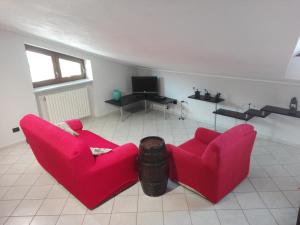 un soggiorno con 2 sedie rosse e una TV di La Sofiètta a Borgo San Dalmazzo