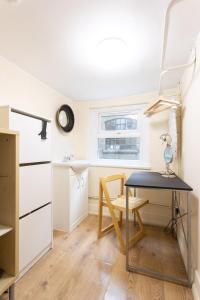 Il comprend une petite cuisine avec un bureau et une table. dans l'établissement Tavistock Place Rooms by MoreThanStays, à Londres