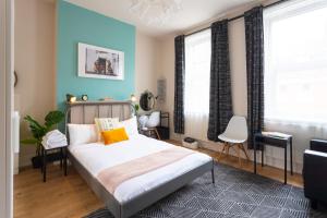 a bedroom with a bed and a blue wall at Tavistock Place Rooms by MoreThanStays in London