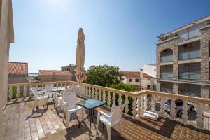 a balcony with a table and chairs on a building at Guest House Lotos in Bečići