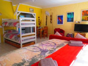 a bedroom with a bunk bed and a living room at Footprints of Knysna in Knysna