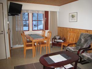 ein Wohnzimmer mit einem Tisch und einem Sofa in der Unterkunft Saariselän Marjamajat Apartment Sopuli in Saariselkä