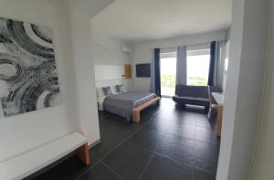 una camera da letto con un letto, un divano e una sedia di Oasis Park Hotel a Torre dell'Orso
