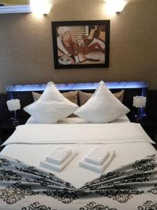 1 cama blanca grande con 2 toallas plegables. en Casa Teilor, en Piteşti