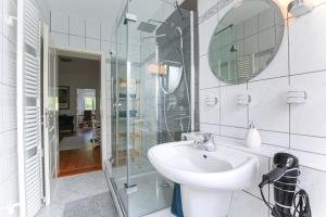 a white bathroom with a sink and a mirror at Ferienwohnung Leipzig Land in Naunhof +9 photos