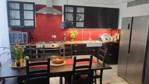 a kitchen with a table and a red wall at Sopron City Apartment in Sopron