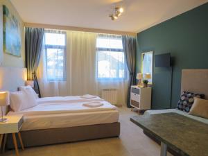 - une chambre avec un grand lit et un canapé dans l'établissement Rivendell Apartments Flora Complex, à Borovets