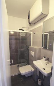 ein Bad mit einer Dusche, einem WC und einem Waschbecken in der Unterkunft Seafront rooms in Hvar
