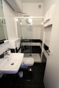 W łazience znajduje się biała umywalka i prysznic. w obiekcie Seafront rooms w Hvarze