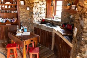 cocina con mesa de madera y fregadero en Moinho da Fadagosa, en Mação