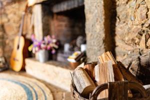 a stone fireplace with a guitar and a bench at Moinho da Fadagosa in Mação