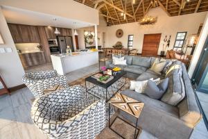 un soggiorno a pianta aperta con divano e sedie di Moya Safari Lodge & Villa a Hoedspruit