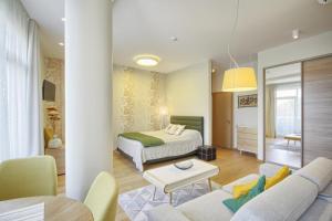 ein Hotelzimmer mit einem Bett und einem Wohnzimmer in der Unterkunft Valensia Apartment in Druskininkai