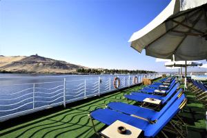 a row of blue chairs and an umbrella on a cruise ship at Iberotel Crown Empress Nile Cruise - Every Monday from Luxor for 07 & 04 Nights - Every Friday From Aswan for 03 Nights in Luxor