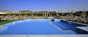 a large blue swimming pool in front of a building at Iberotel Crown Empress Nile Cruise - Every Monday from Luxor for 07 & 04 Nights - Every Friday From Aswan for 03 Nights in Luxor +18 photos