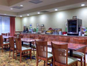 Un restaurante con mesas y sillas de madera y un bar. en Country Inn & Suites by Radisson, Fredericksburg, VA, en Fredericksburg