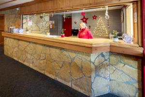 a woman standing behind a counter in a restaurant at Résidence Capfun Les Adrets in Isola 2000